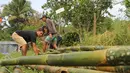 Warga menata bambu untuk membangun kamp pengungsian Gunung Agung di lahan milik dinas pertanian, Karangasem, Bali, Senin (27/11). BNPB mengatakan ada 22 desa yang warganya harus mengungsi terkait status awas Gunung Agung. (Liputan6.com/Andi Jatmiko)