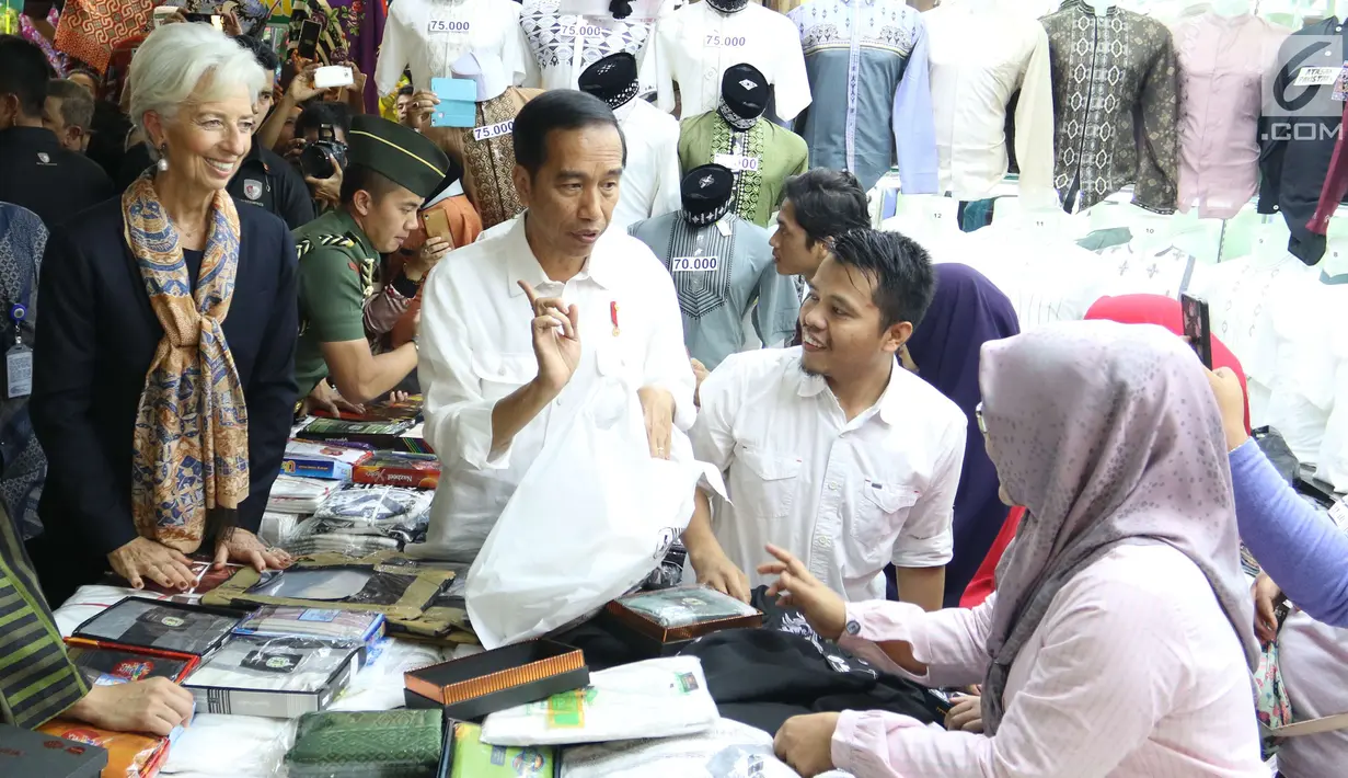 Presiden Jokowi menemani Direktur Pelaksana IMF Christine Lagarde memilih baju koko di salah satu toko Blok A Pasar Tanah Abang, Jakarta, Senin (26/2). Baju koko tersebut dibeli Lagarde sebagai oleh-oleh untuk sang suami. (Liputan6.com/Angga Yuniar)