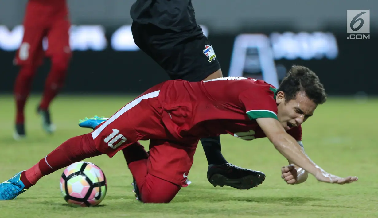 Pemain depan Indonesia U-19, Egy Maulana Vikri terjatuh saat melewati adangan pemain Thailand U-19 di Stadion Wibawa Mukti, Cikarang, Minggu (8/10). The Guardian menyoroti Egy saat menjadi top scorer Piala AFF U-18. (Liputan6.com/Helmi Fithriansyah)