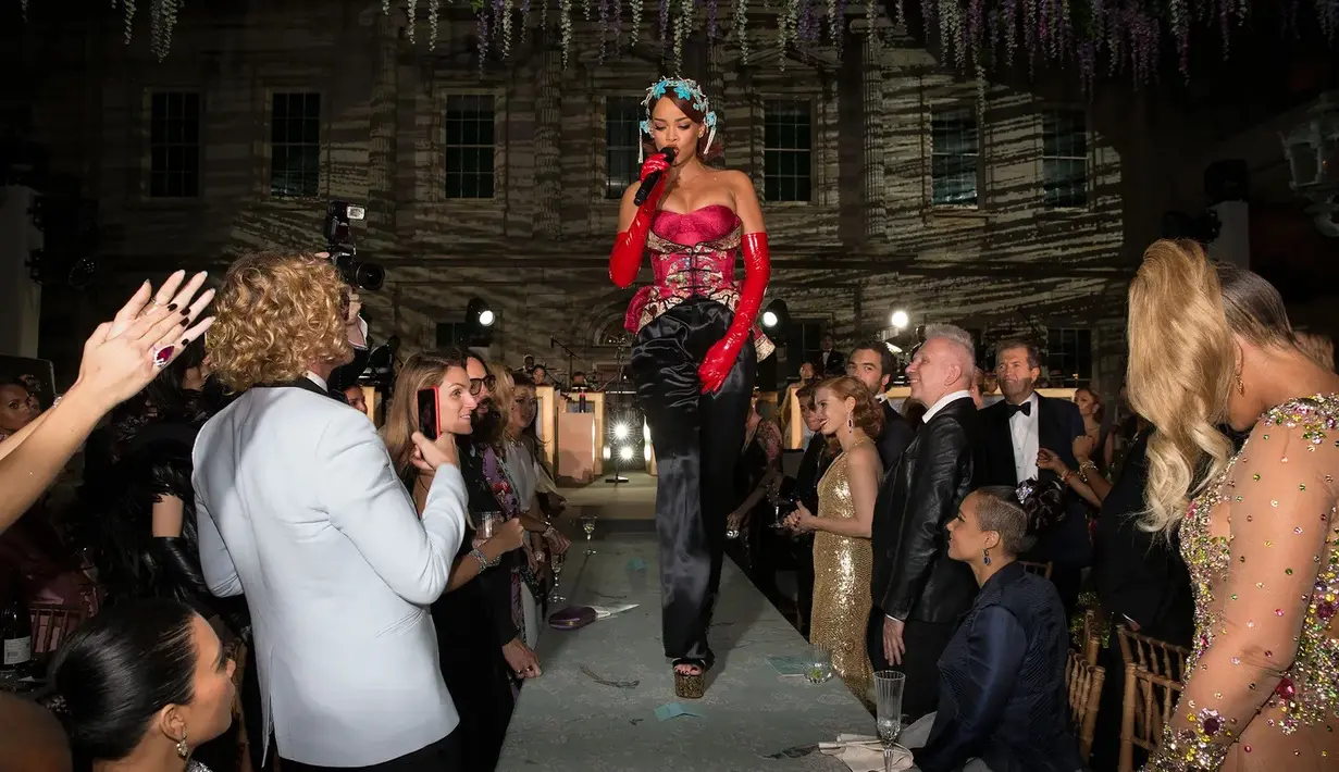 Rihanna menari di atas meja. Pada Met Gala 2015, Rihanna dengan gaun dari Guo Peinya membuka acara dengan pertunjukan luar biasa, yaitu menyanyikan "Bitch Better Have My Money" di atas meja makan. Foto: Vogue.
