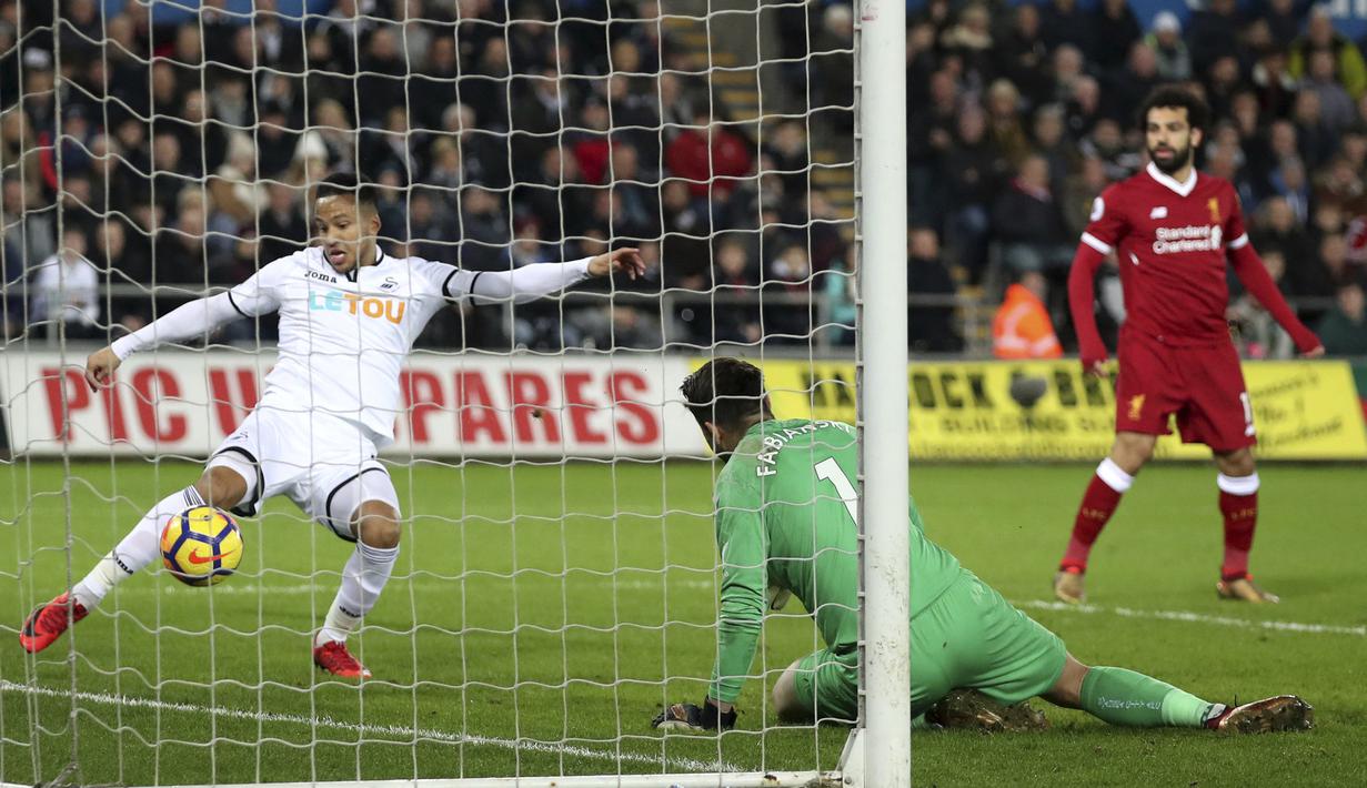 Pemain Swansea City, Martin Olsson (kiri) menghalau bola dari mulut gawang saat melawan Liverpool pada lanjutan Premier League di Liberty Stadium, Swansea, (22/1/2018). Liverpool kalaj dari Swansea 0-1.  (Nick Potts/PA via AP)