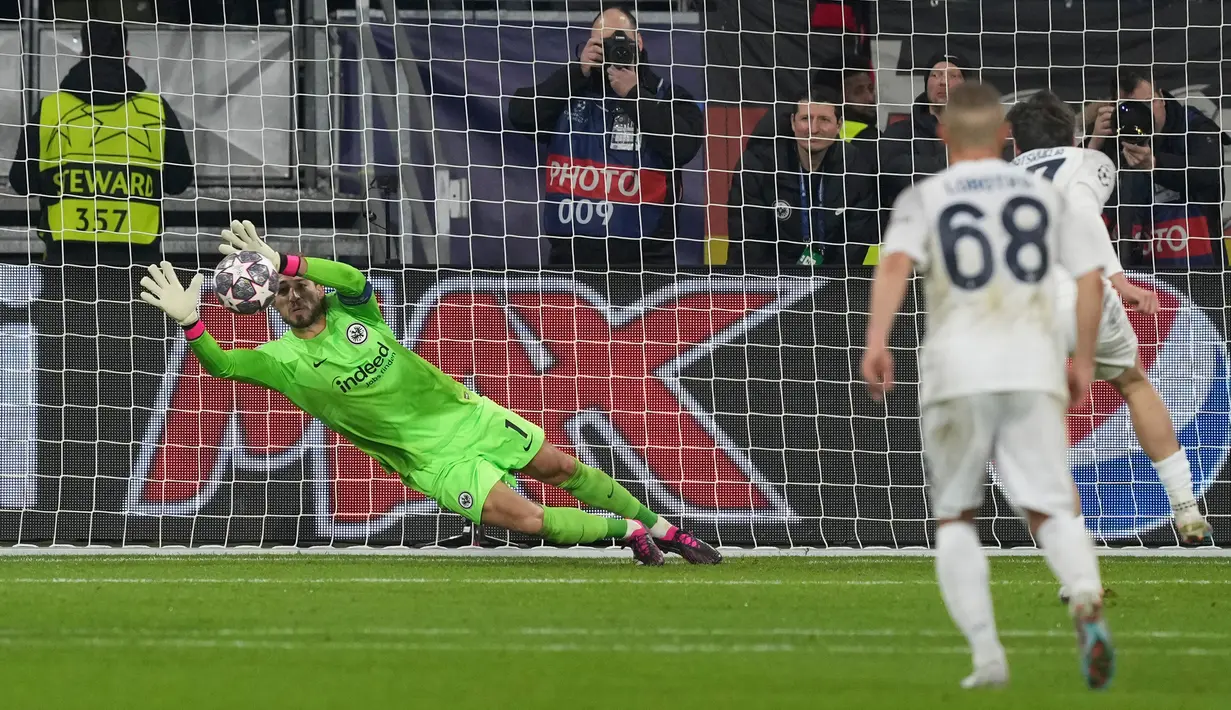 Kiper Eintracht Frankfurt Kevin Trapp (kiri) melakukan penyelamatan tendangan penalti dari pemain Napoli Khvicha Kvaratskhelia pada pertandingan sepak bola babak 16 besar Liga Champions di Deutsche Bank Arena, Frankfurt, Jerman, 21 Februari 2023. Napoli mengalahkan Eintracht Frankfurt dengan skor 2-0. (AP Photo/Michael Probst)