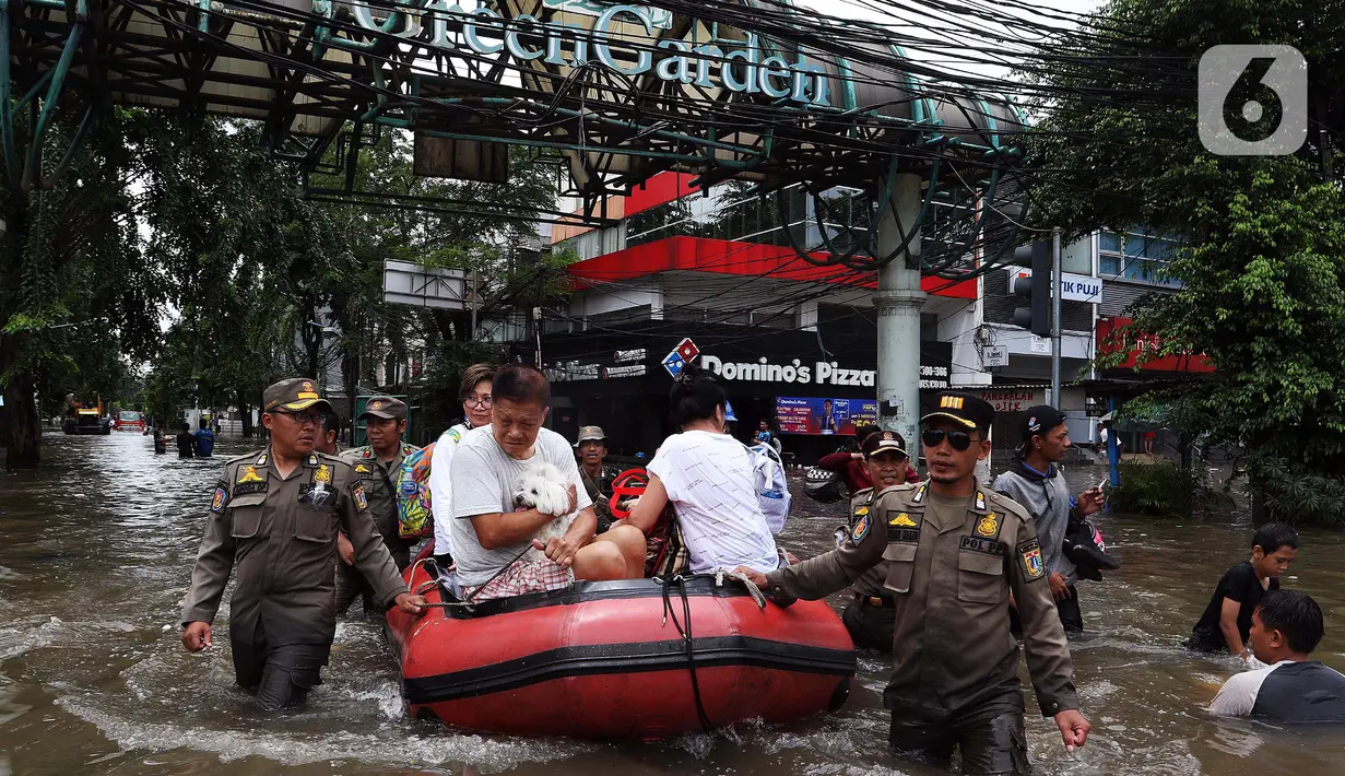 Petugas menggunakan perahu karet mengangkut warga melintasi banjir di kawasan Green Garden, Jakarta Barat, Selasa (25/2/2020). Hujan yang mengguyur kawasan Jakarta membuat kawasan tersebut tergenang banjir setinggi 60-80 cm. (Liputan6.com/Johan Tallo)