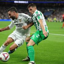 Bek Real Madrid asal Spanyol, Dani Carvajal, berebut bola dengan bek Real Betis asal Prancis, Romain Perraud, selama pertandingan sepak bola liga Spanyol antara Real Madrid CF dan Real Betis di stadion Santiago Bernabeu, Madrid, pada 1 September 2024.Thomas COEX / AFP