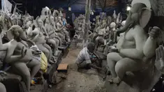 Perajin membuat patung Dewa Ganesha di sebuah bengkel di pinggiran Hyderabad, India, Rabu (18/8/2021). ​Patung ramah lingkungan yang dibuat jelang perayaan Ganesh Chaturthi tersebut dibuat dari lumpur, serat rami, dan bambu untuk mengurangi polusi air. (NOAH SEELAM/AFP)