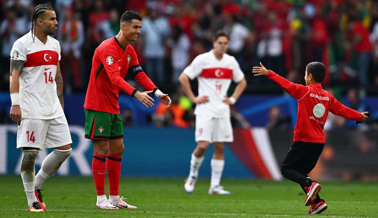 Laga Euro 2024 Grup F antara Turki dan Portugal terganggu oleh ulah sejumlah suporter yang masuk ke lapangan. (PATRICIA DE MELO MOREIRA/AFP)