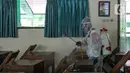 Petugas PMI menyemprotkan disinfektan di salah satu ruang SMPN 97 Jakarta, Kamis (3/2/2022). Sejumlah sekolah mengantisipasi penyebaran COVID-19 dengan penyemprotan disinfektan, tes usap PCR peserta didik dan tenaga kependidikan juga menggelar Pembelajaran Jarak Jauh. (Liputan6.com/Faizal Fanani)