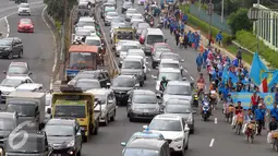 Sejumlah buruh berjalan menuju Gedung DPR RI, Jakarta, Minggu (1/5) Lalu lintas menjadi tersendat imbas dari Hari Buruh Internasional yang jatuh pada 1 Mei. (Liputan6.com/Helmi Afandi)