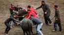 Para peternak mencoba untuk memisahkan dua sapi Herens saat bertanding pada babak kualifikasi finale nationale de la race d'Herens di Aproz, Swiss, Minggu (5/5/2019). Di sini, para peternak akan memastikan hewan ternaknya tidak mengalami luka serius. (Valentin Flauraud/Keystone via AP)