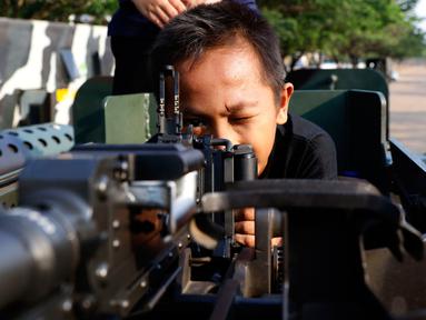 Anak-anak tampak senang memainkan senjata ketika menaiki Panser Anoa dalam pameran road to campus Alat Utama Sistem Persenjataan (Alutsista) di kawasan Boulevard Universitas Indonesia, Depok, Jawa Barat, Kamis (27/8/2015). (Liputan6.com/Yoppy Renato)