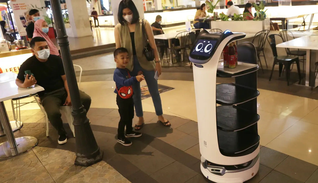 Robot bernama “Bellabot” melintasi pengunjung food court di Tangcity Mal, Kota Tangerang, Rabu (27/10/2021). Robot itu bertugas sebagai pramusaji guna meminimalisir sentuhan langsung antara pegawai dan pengunjung di saat aktivitas mal mulai beroperasi dalam masa pandemi. (Liputan6.com/Angga Yuniar)