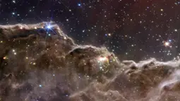 Gambar ini dirilis oleh NASA pada 12 Juli 2022, menggabungkan kemampuan dua kamera James Webb Space Telescope untuk menciptakan pemandangan yang belum pernah dilihat sebelumnya dari wilayah pembentuk bintang di Nebula Carina. Ditangkap dalam cahaya inframerah oleh Near-Infrared Camera (NIRCam) dan Mid-Infrared Instrument (MIRI), gambar gabungan ini mengungkapkan area kelahiran bintang yang sebelumnya tidak terlihat. (NASA, ESA, CSA, STScI via AP)