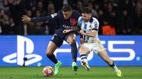 Pemain PSG, Kylian Mbappe (kiri) berebut bola dengan pemain Real Sociedad, Javier Galan pada laga leg pertama 16 besar Liga Champions 2023/2024 di Parc des Princes, Paris, Prancis, Kamis (15/02/2024) WIB. (AFP/Franck Fife)