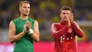 Pemain Bayern Munchen, Manuel Neuer dan Thomas Mueller menyapa suporter usai dikalahkan Dortmund pada laga Piala Super DFL di Stadion Signal Iduna, Dortmund, Sabtu (3/8). Dortmund menang 2-0 atas Munchen. (AFP/Ina Fassbender)