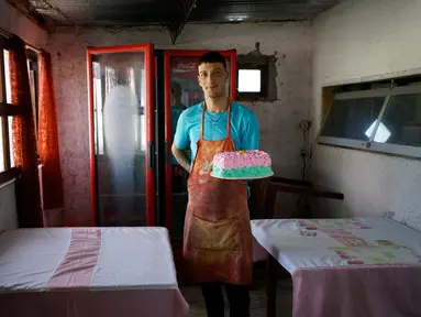 Narapidana Nelson Avantti memegang kue di toko rotinya di Penjara Punta de Rieles, Montevideo, Uruguay, 18 Mei 2019. Uang untuk memulai bisnis seperti milik Avantti berasal dari keluarga narapidana atau bank yang sebagian besar dikelola oleh narapidana sendiri. (AP Photo/Matilde Campodonico)