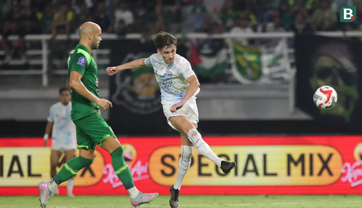 Pemain PSIM Yogyakarta, Cofre Deri Antony (kanan) berhasil melakukan tendangan ke gawang Persebaya Surabaya pada pertandingan pembuka BRI Super League 2025/2026 di Stadion Gelora Bung Tomo, Jumat (08/08/2025) malam WIB. (Bola.com/Abdul Aziz)