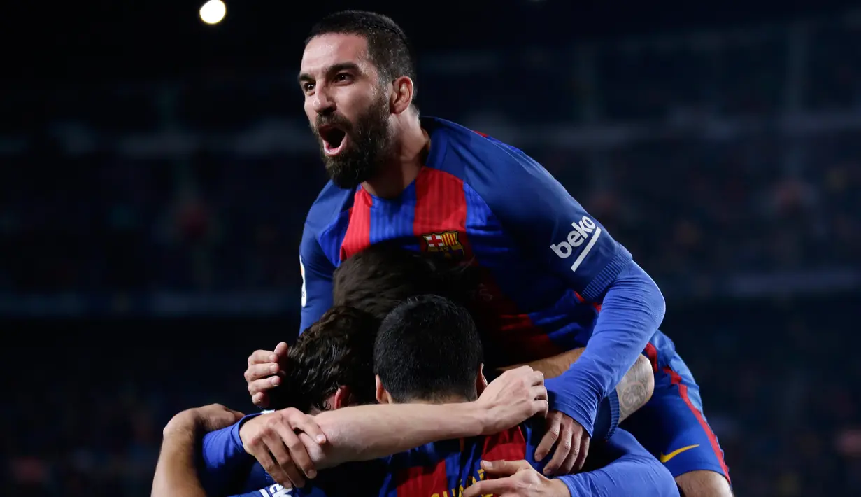 Gelandang Barcelona Arda Turan bersama Luis Suarez merayakan gol pembuka ke gawang Atletico Madrid pada leg kedua semifinal Copa del Rey di Estadio Camp Nou, Selasa (7/2). Barca lolos ke final dengan keunggulan aggregat 3-2. (AP Photo/Manu Fernandez)