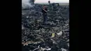 Petugas saat berada di puing-puing reruntuhan pesawat Malaysia Airlines MH-17 yang jatuh di Grabovo, wilayah Donetsk, Ukraina , Kamis (17/7/14). (REUTERS/Maxim Zmeyev)
