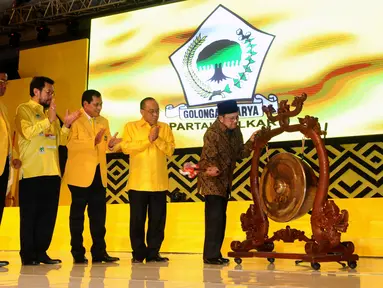 Presiden RI ketiga, BJ Habibie (kanan) memukul gong tanda dibukanya Rapimnas Partai Golkar 2016 di Jakarta, Sabtu (23/1/2016). Rapimnas digelar setelah Mahkamah Partai merekomendasikan penyelesaian konflik lewat Munas. (Liputan6.com/Helmi Fithriansyah)