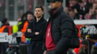 Pelatih kepala Bayer Leverkusen asal Spanyol, Xabi Alonso (kiri), dan pelatih kepala Bayern Munchen asal Belgia, Vincent Kompany, terlihat selama pertandingan leg kedua babak 16 besar Liga Champions UEFA antara Bayer Leverkusen dan Bayern Munchen di Leverkusen, Jerman Barat, Rabu dini hari WIB (12-3-2025). (Pau BARRENA/AFP)