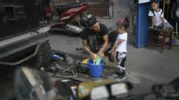 Saat tidak ada pertunjukkan, dirinya bekerja di bengkel sambil menginspirasi anak muda lain yang mau mengikuti jejaknya dengan cara mengajari mereka untuk mengganti oli dan tune up motor. (Foto: AP/Matias Delacroix)