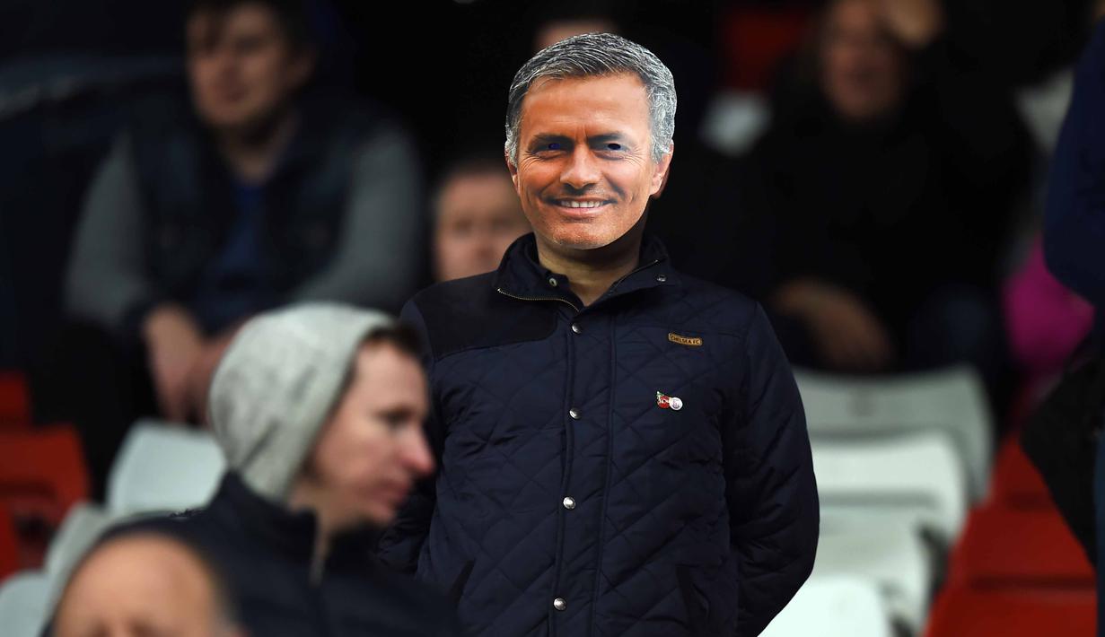 Suporter menggunakan topeng pelatih Chelsea Jose Mourinho pada laga Liga Premier Inggris di Stadion Britania, Minggu (8/11/2015) dini hari WIB. Mourinho dilarang mendampingi timnya oleh Football Association ( FA ). (AFP Photo/PAUL Ellis)