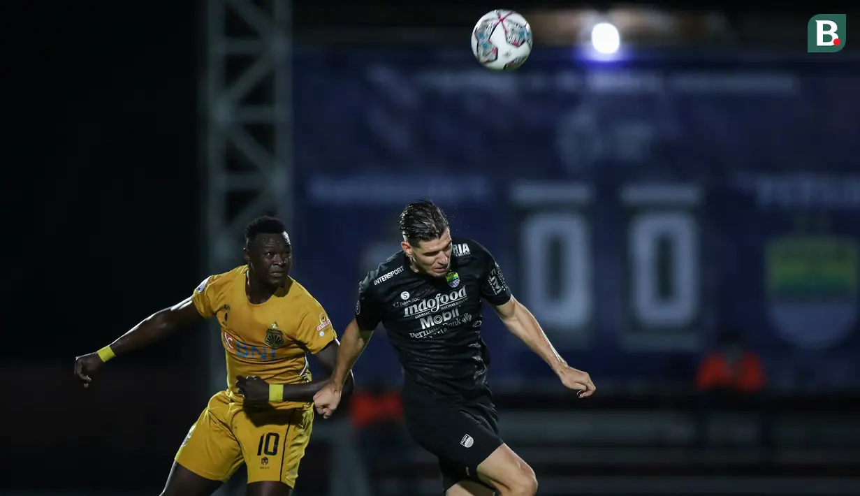 Pemain Bhayangkara FC, Ezechiel Ndouassel (kiri) berebut bola dengan pemain Persib Bandung, Nick Kuipers dalam laga pekan ke-7 BRI Liga 1 2021/2022 di Stadion Moch Soebroto, Magelang, Sabtu (16/10/2021). (Bola.com/Bagaskara Lazuardi)