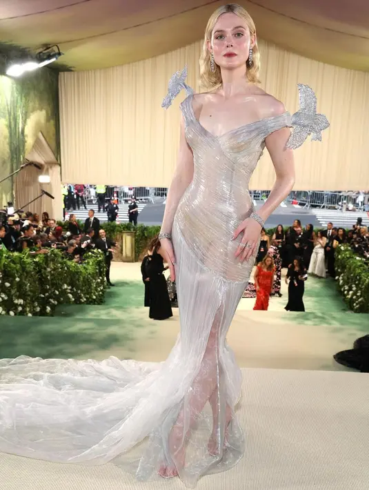 Elle Fanning tampil layaknya Sleeping Beauty Princess dengan gaun shimmer dari Balmain. Gaun bustier organza yang dilapisi dengan 4 lapisan resin untuk efek kaca trompe l'oeil. [@balmain]