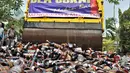 Buldozer melindas ribuan botol minuman keras ilegal saat dimusnahkan di Kantor Bea Cukai Marunda, Jakarta, Selasa (2/10). Total barang bukti rokok dan minuman keras ilegal yang dimusnahkan sekitar Rp 1,1 miliar. (Merdeka.com/Iqbal Nugroho)