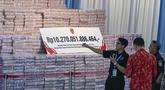 Para pejabat menyiapkan tumpukan uang kertas rupiah senilai sekitar 586,8 juta USD, yang disita dari berbagai kasus korupsi dan denda lingkungan, sebelum upacara penyerahan dari Kejaksaan Agung kepada pemerintah Indonesia di gedung Kejaksaan Agung di Jakarta pada Rabu 13 Mei 2026. Kejaksaan Agung (Kejagung) kembali menyerahkan uang tunai hasil sitaan dan denda administratif penertiban kawasan hutan senilai Rp 10,27 triliun ke kas negara. (BAY ISMOYO/AFP)