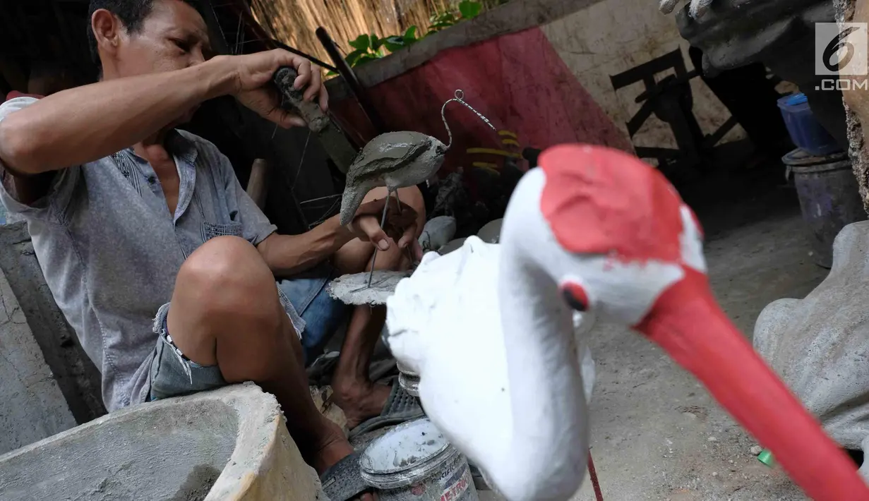 Pengrajin membuat patung di Jakarta, Jumat (16/3). Pemerintah berencana menurunkan tarif pajak penghasilan atas penjualan dibawah Rp4,8 miliar yang dikenakan tarif PP 46 sebesar 1% per bulan dari jumlah omzet, menjadi 0,5%. (Liputan6.com/Angga Yuniar)