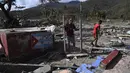 Seorang pria memegang gerbang rumah yang rusak akibat Badai Melissa di desa Boca de Dos Rios, provinsi Santiago de Cuba, Kuba, pada Kamis 30 Oktober 2025. Pada Rabu (29/10/2025), pagi waktu setempat, sejumlah pejabat melaporkan beberapa rumah runtuh, jalan pegunungan terblokir, dan atap bangunan beterbangan akibat terjangan Badai Melissa. 
(YAMIL LAGE/AFP)