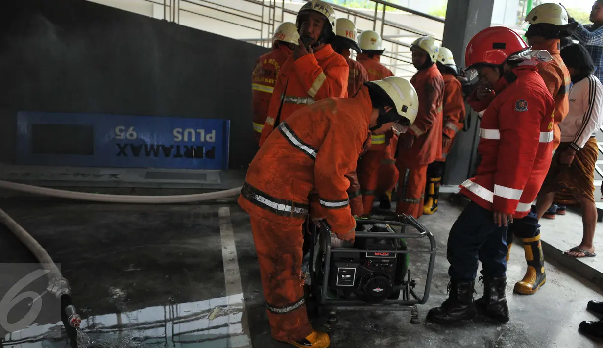 Petugas pemadam kebakaran dikerahkan ke lokasi kebakaran di SPBU Abdul Muis, Jakarta, Senin (12/9). Akibat kebakaran tersebut, SPBU ditutup sementara sampai menunggu penyelidikan lebih lanjut. (Liputan6.com/Gempur M Surya)