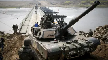 Sebuah tank AS tentara M1A2 melintasi jembatan pontoon selama latihan tentara AS-Korsel di persimpangan sungai dekat zona demiliterisasi yang memisahkan antara Korsel dan Korut di Incheon (8/4). (REUTERS/Kim Hong-Ji)