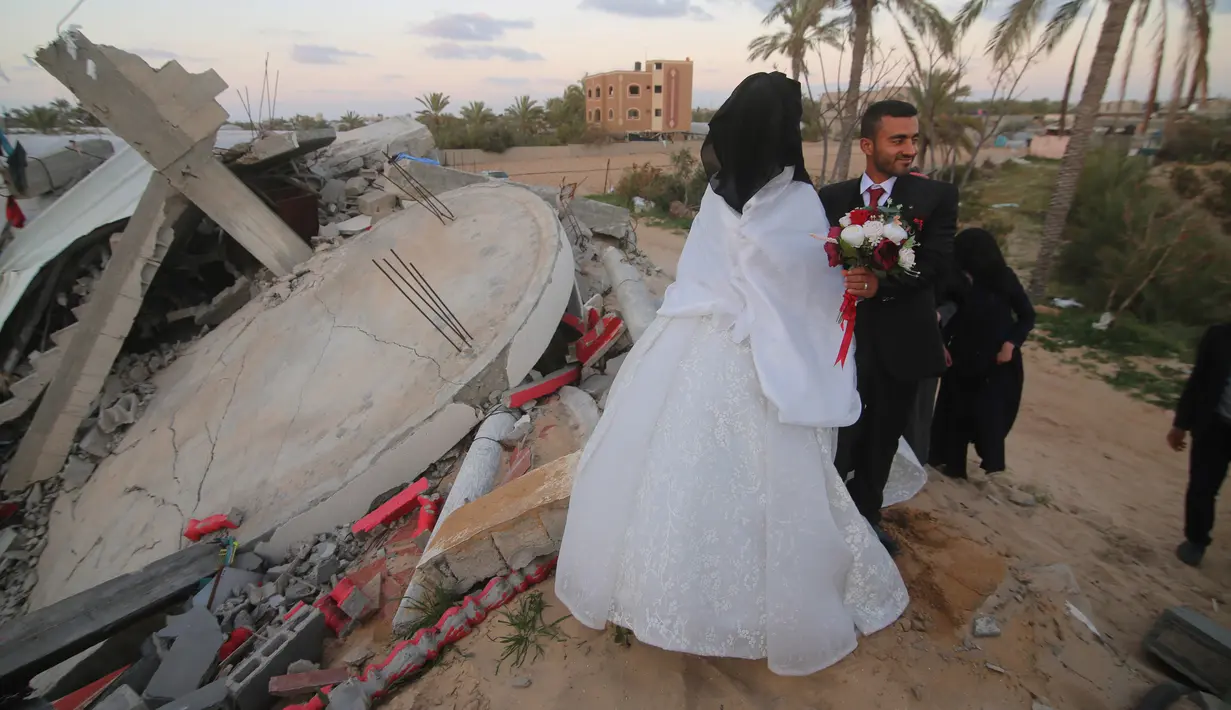 Mohammed Zourab dan pengantin perempuannya menggelar pernikahan di atas reruntuhan rumahnya di Kota Khan Younis, Jalur Gaza, 1 Maret 2020. Upacara pernikahan warga Palestina digelar di atas reruntuhan salah satu rumah yang hancur tiga bulan lalu akibat serangan jet Israel. (Xinhua/Khaled Omar)