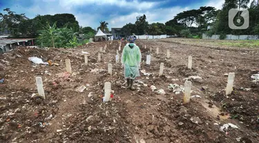 Seorang petugas berjalan di antara makam jenazah dengan protokol COVID-19 di TPU Srengseng Sawah 2, Jakarta, Selasa (9/2/2021). TPU Srengseng Sawah 2 yang sudah lebih dari sepekan dibuka untuk pemakaman dengan protokol COVID-19 ini mampu menampung seribu lebih liang lahat. (merdeka.com/Arie Basuki)