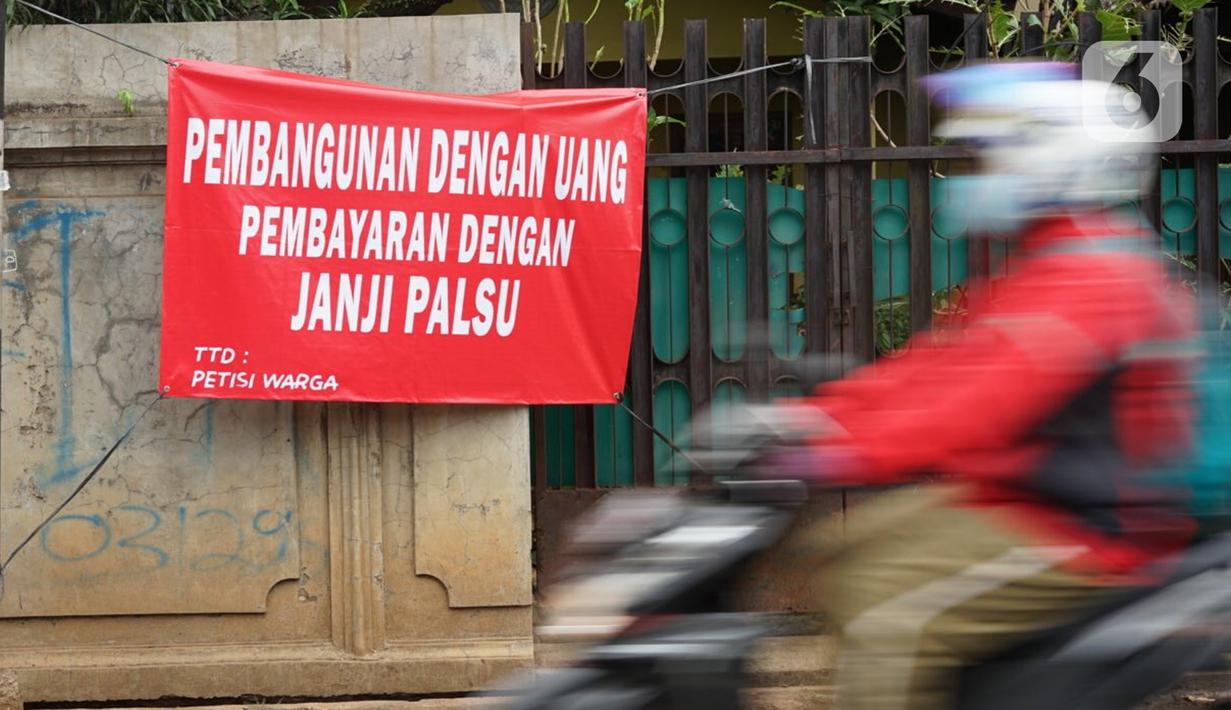 Pengendara motor melintas di depan poster protes warga terhadap pembangunan flyover di kawasan Tanjung Barat, Jakarta, Rabu (15/7/2020). Dalam poster protes tersebut, warga menuntut agar pembayaran pelunasan pembebasan lahan segera diselesaikan secara serentak. (Liputan6.com/Immanuel Antonius)