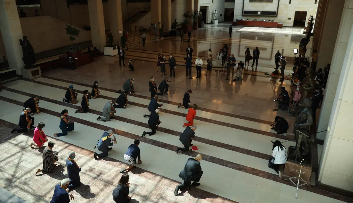 Ketua DPR Nancy Pelosi bersama anggota Kongres AS dari Fraksi Demokrat berlutut dan mengheningkan cipta di Gedung Kongres AS, Senin (8/5/2020). Mereka berlutut selama 8 menit 46 detik, atau selama waktu yang sama saat Derek Chauvin menginjak leher George Floyd. (Chip Somodevilla/Getty Images/AFP)