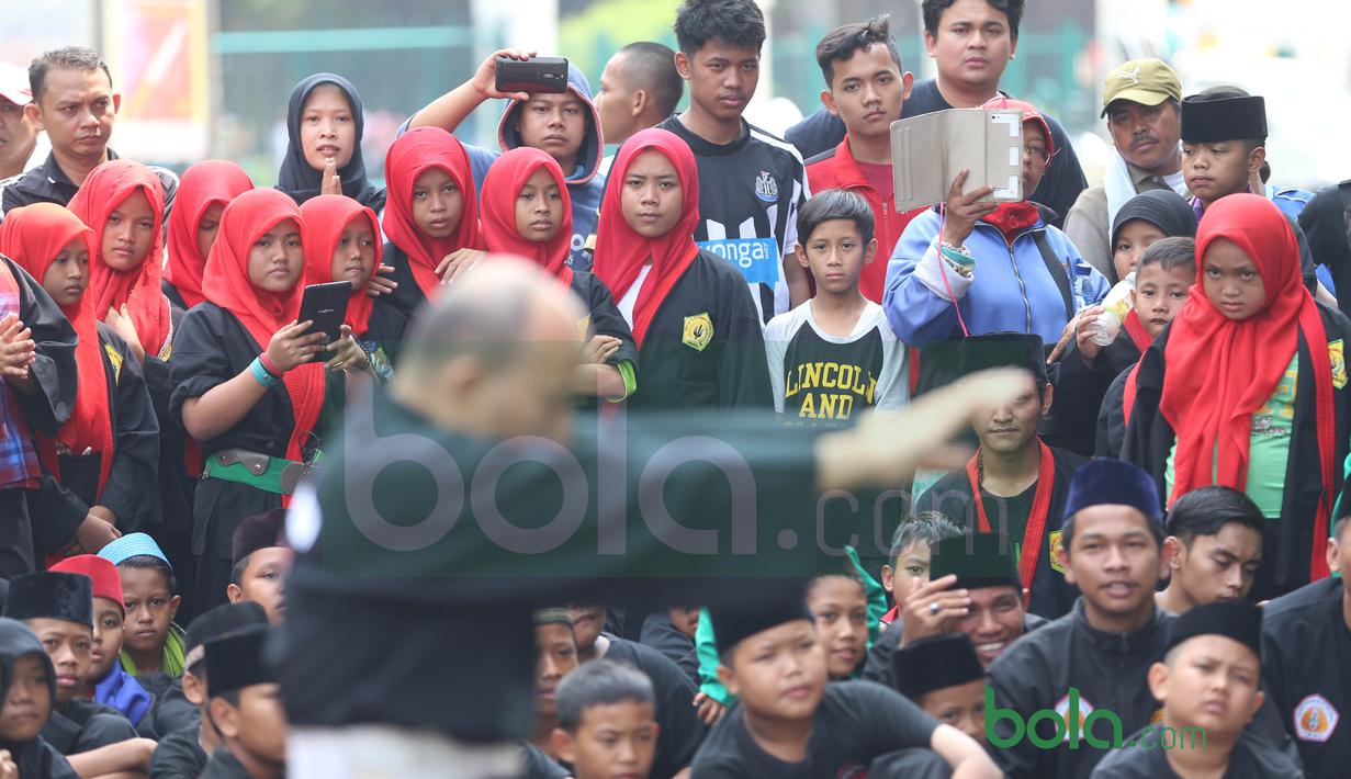 Para Pendekar wanita Betawi saat menyaksikan gerakan Silat Betawi di Kawasan Senayan, Jakarta, Minggu (8/11/2015). Kegiatan ini merupakan  bagian dari Silahturahmi Main Pukul Betawi. (Bola.com/Nicklas Hanoatubun)