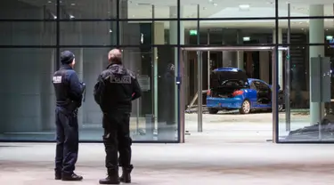 Polisi memeriksa kerusakan di lobi kantor Partai Sosial Demokratik Jerman (SPD) setelah sebuah mobil menabrakan gedung dengan sengaja di Berlin (25/12). Pelaku pria berusia 58 tahun menabrakan diri pada malam Natal. (AFP PHOTO / Ganjil Andersen)