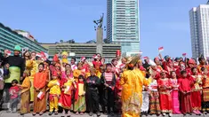Sejumlah murid sekolah minggu Gereja Eban Haezer mengenakan baju adat sambil melambaikan bendera nasional di Bundaran HI Jakarta, Minggu (21/8). Menyanyikan lagu Indonesia Raya dan lagu daerah, mereka memperingati HUT RI ke 71. (Liputan6.com/Angga Yuniar)