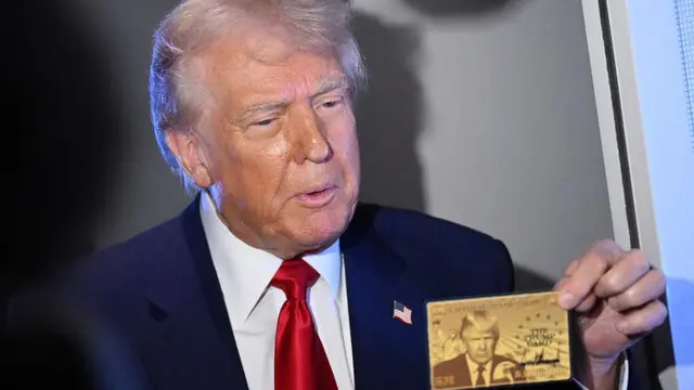 Donald Trump pamer prototipe yang memperlihatkan wajahnya dan tulisan “Trump Card”. (AFP)