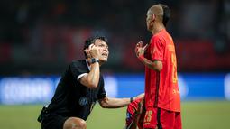 Wasit asal Jepang, Futoshi Nakamura (kiri), berdialog menggunakan bahasa isyarat dengan pemain Persija Jakarta, Riko Simanjuntak, saat pertandingan pekan ke-23 BRI Liga 1 2023/2024 antara Persija Jakarta melawan PSS Sleman yang berlangsung di Stadion Patriot Chandra Bhaga, Bekasi, Sabtu (16/12/2023). Futoshi Nakamura juga terlihat sering melakukan komunikasi dengan pemain yang membuat timbul rasa respek. (Bola.com/Bagaskara Lazuardi)