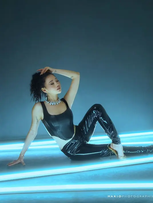 Wendy Walters mengenakan atasan cropped top tanpa lengan berwarna hitam dari bahan karet. Ia padukan dengan celana panjang hitam. Foto: Instagram.