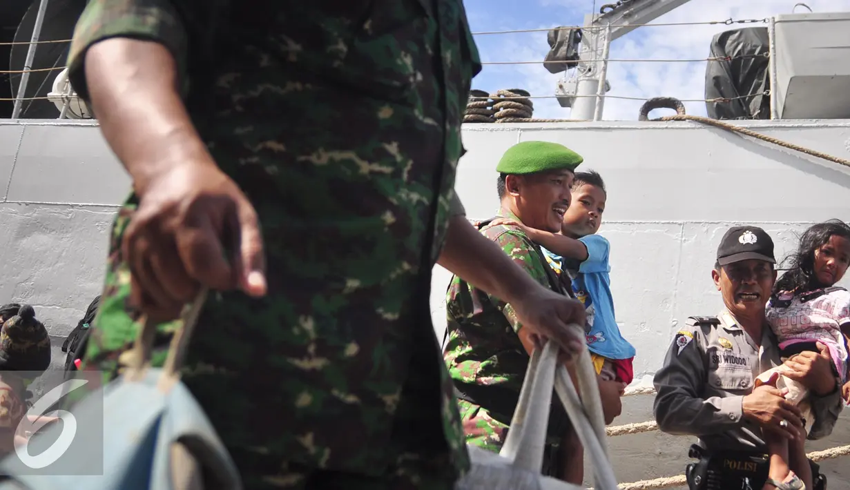 Petugas mengendong seorang anak di Pelabuhan Tanjung Emas, Semarang , Senin (25/1). Total ada 42 orang eks Gafatar yang sakit, terinci 28 dewasa dan 14 anak-anak. mengalami menderita dehidrasi, demam, dan  muntah.  (Liputan6.com/Gholib)