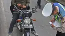 Polisi menilang pengendara sepeda motor yang menerobos jalur Transjakarta di Jalan Sultan Agung, Manggarai, Jakarta, Rabu (12/2/2020). Pengendara kerap melintasi jalur Transjakarta untuk menghindari kemacetan lalu lintas. (Liputan6.com/Herman Zakharia)