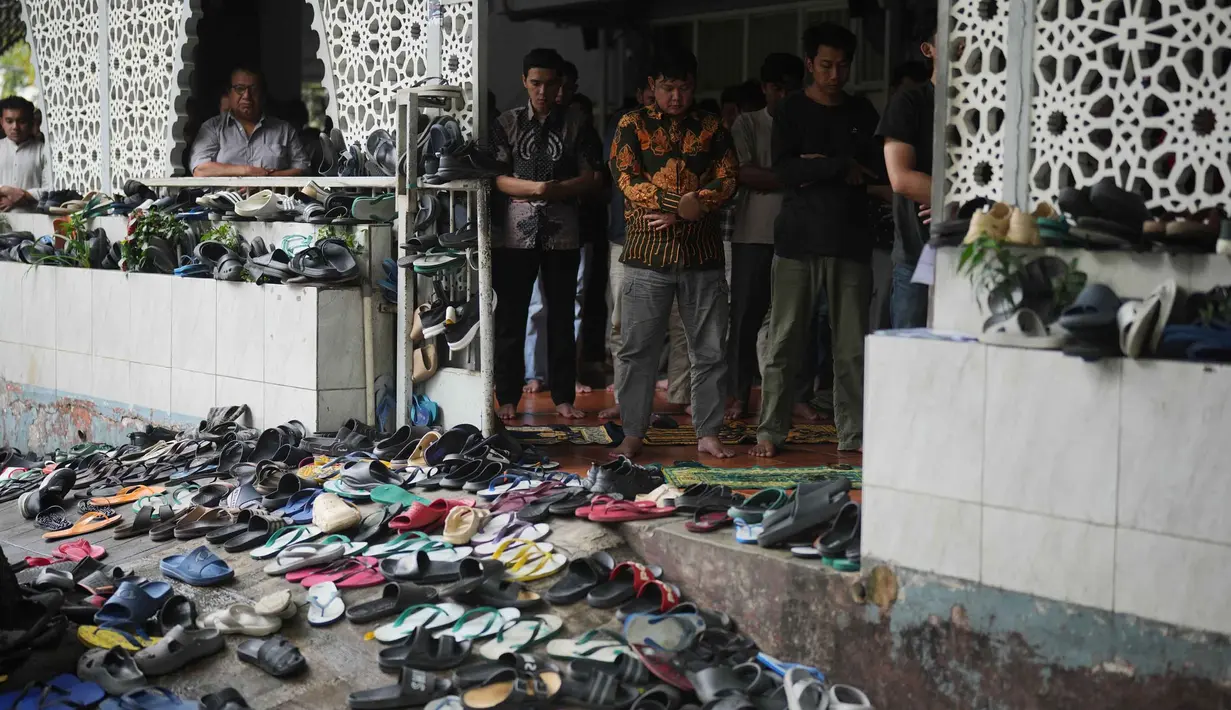 Sepatu dan sandal ditinggalkan di luar saat orang-orang melaksanakan salat Jumat di sebuah masjid, selama bulan suci Ramadan di Jakarta, Jumat 20 Februari 2026. Ribuan umat muslim di Indonesia melaksanakan ibadah salat Jumat pertama pada Ramadan 1447 Hijriah. (AP Photo/Dita Alangkara)