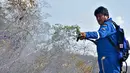 Presiden Bolivia Evo Morales menyemprotkan air saat berusaha memadamkan api dalam kebakaran hutan di pinggiran Robore, Bolivia, Selasa (27/8/2019). Kebakaran telah menghancurkan lebih dari 1,2 juta hektare hutan Bolivia tahun ini. (Raul Martinez/Bolivia's Communication Ministry press office via AP)