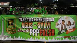 Simpatisan pasangan Agus-Slyvi membentangkan spanduk di Jakarta, Selasa (25/10). Pada hari ini KPUD menggelar acara pengambilan nomer urut Cagub dan Wagub serta Penyerahan Keputusan tentang penetapan nomer urut pasangan. (Liputan6.com/Johan Tallo)