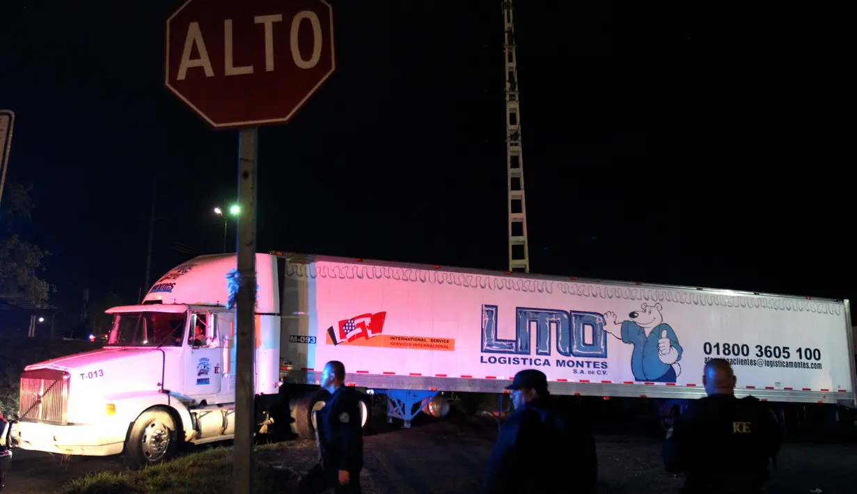 Sebuah kontainer truk trailer berisi lebih dari 100 mayat tak teridentifikasi dipindahkan dari Guadalajara menuju Jalisco di Meksiko, Senin (17/9). Pemerintah setempat tengah mencari solusi jangka panjang untuk menyimpan mayat-mayat itu. (AFP/Ulises Ruiz)